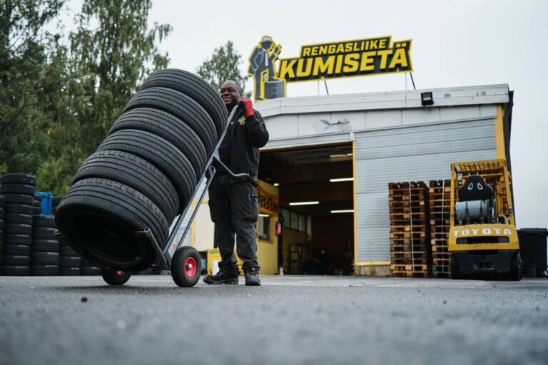 Yrityskuvaus markkinointikuva Rengasliike Kumisetä Kenneth poseeraamassa renkaiden kanssa