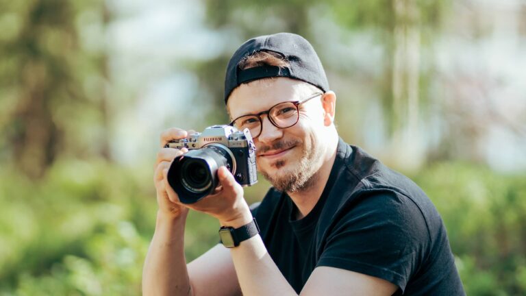 Valokuvaaja Niklas Isberg Jyväskylän Mustalammella metsässä kamera kädessä
